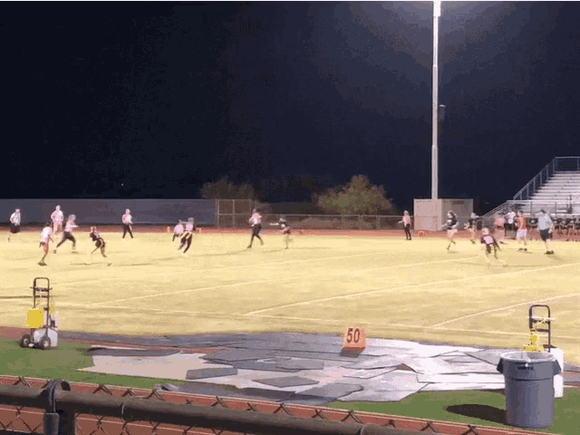 a football game is being played on a field with a yellow sign that says 50 on it