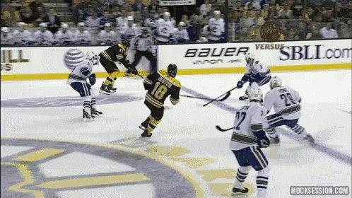 a hockey game is being played in front of a bauer ad
