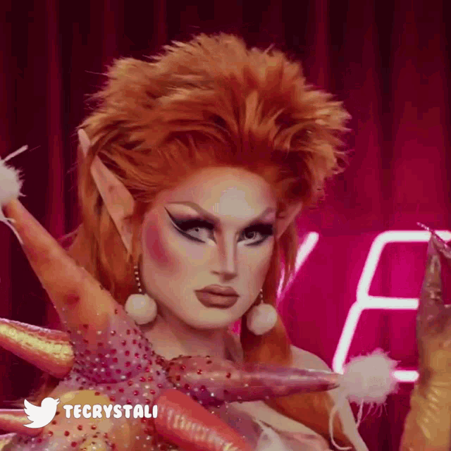 a close up of a drag queen 's face with the twitter logo in the corner
