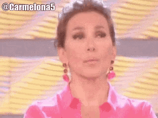 a woman wearing a pink shirt and earrings is making a funny face with the hashtag carmelona5