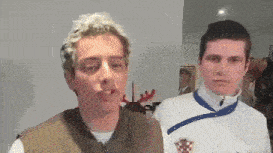 two young men are standing next to each other and one of them is wearing a white shirt with a croatia emblem on it