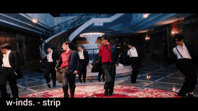 a group of men in suits are dancing in a room with the words w-inds-strip below them