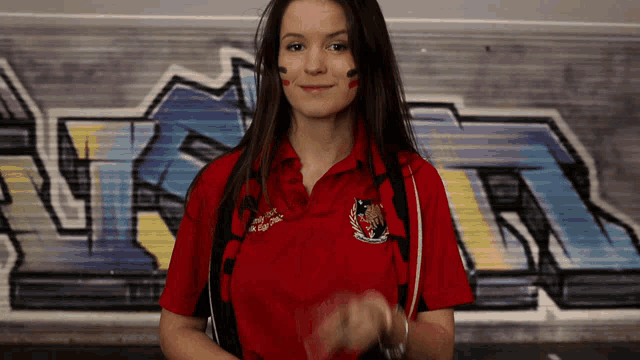 a woman wearing a red shirt that says ' rugby ' on it
