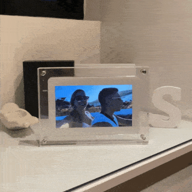 a picture of a man and a woman in a picture frame with the letter s next to it