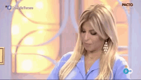 a woman in a blue shirt is on a tv show