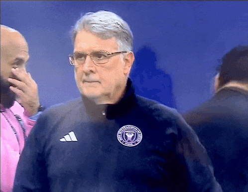a man wearing a jacket with a miami fc logo on it