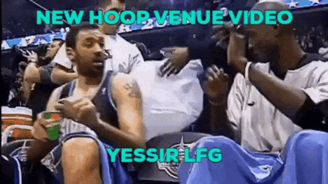 a group of basketball players are sitting in a stadium with the words new hoop venue video
