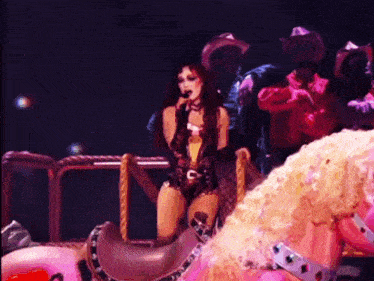a woman is sitting on a rocking horse and singing