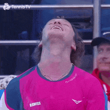 a man wearing a pink k-swiss shirt is looking up