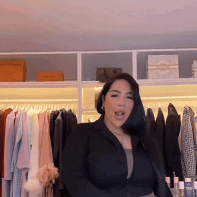 a woman in a black jacket is standing in front of a closet
