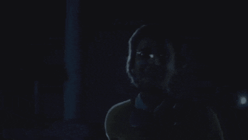 a man and a woman are standing next to each other in the dark .