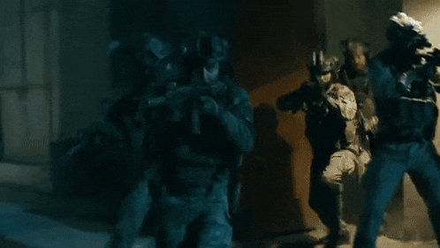 a soldier is holding a gun in the dark