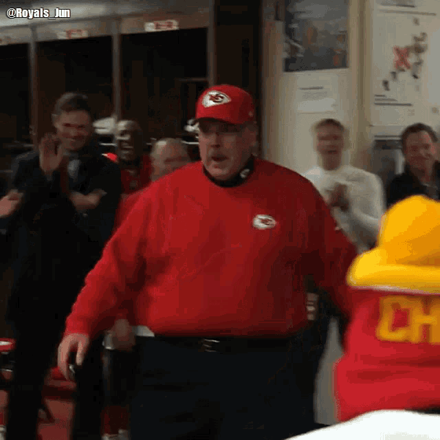 a man wearing a red sweatshirt with a chiefs logo on it