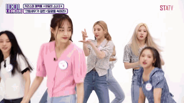 a group of girls are dancing in front of a white background with idol league written on the bottom