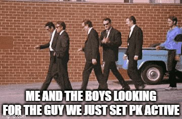 a group of men in suits are walking down a street with a brick wall in the background .