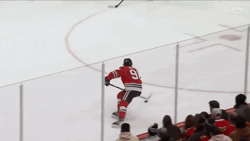 a hockey player is being lifted in the air by a crowd of people .