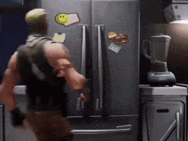 a man is standing in front of a refrigerator with a smiley face sticker on it