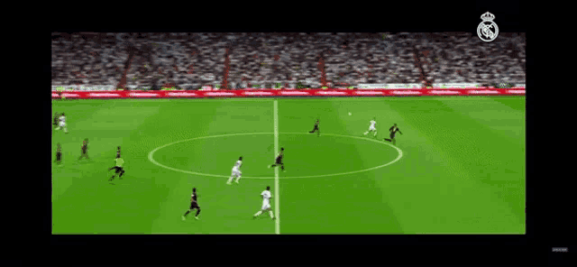 a soccer game is being played on a field with a real madrid logo