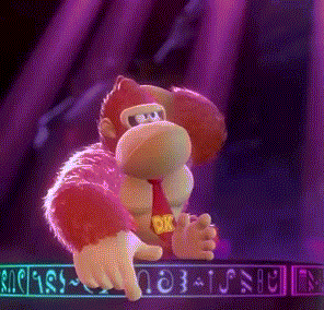 donkey kong is dancing on a stage in a video game while wearing a red tie .