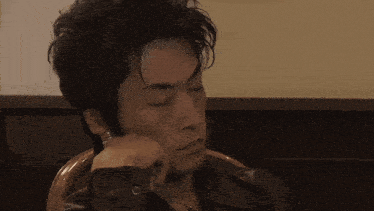 a man with his eyes closed is sitting in a chair