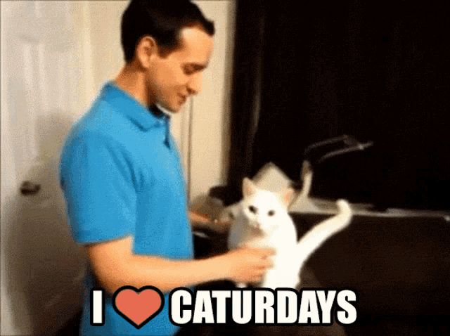a man in a blue shirt petting a white cat with the words i heart caturdays