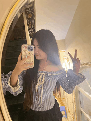 a woman taking a picture of herself in the mirror with her phone