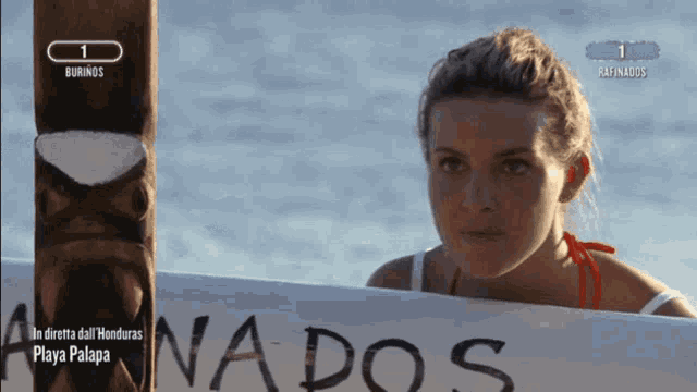 a woman stands in front of a sign that says ' nados '