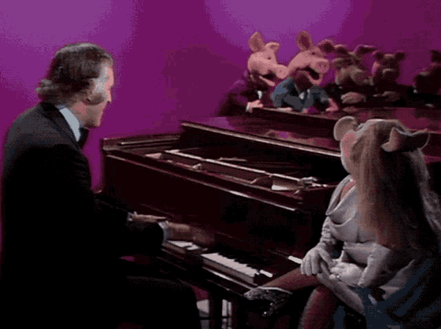 a man in a tuxedo is playing a piano with a group of stuffed pigs behind him