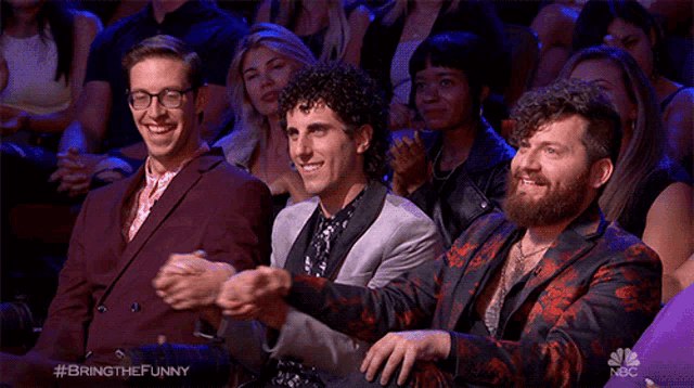 a group of people sitting in a theatre applauding with the hashtag #bringthefunny on the bottom