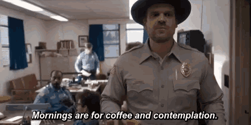 a man in a sheriff 's uniform is standing in a room and says mornings are for coffee and contemplation