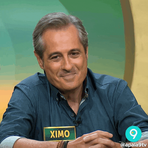 a man with a name tag that says ximo is smiling