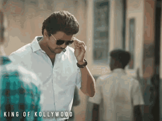 a man wearing sunglasses and a white shirt with the words king of kollywood on the bottom