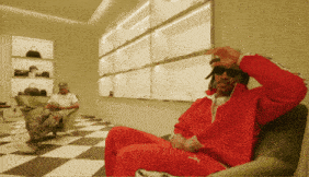 a man in a red tracksuit sits in a chair
