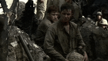 a group of soldiers are sitting on a pile of rocks in a cave