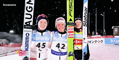 three skiers are posing for a picture with one wearing the number 45