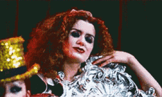 a woman with red hair is wearing a top hat and a fan