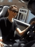 a woman wearing sunglasses is smiling while driving a car