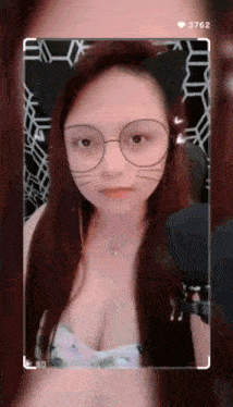 a woman wearing cat ears and glasses is taking a selfie .