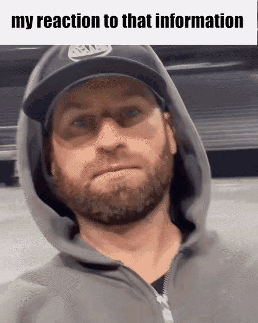 a man with a beard is wearing a hoodie and a hat with the words " my reaction to that information " below him