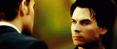 two men are looking at each other in a close up .