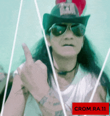 a man wearing sunglasses and a hat giving the middle finger
