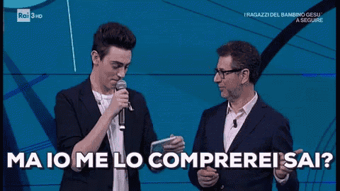 a man holding a microphone next to another man with the words ma io me lo comprerei sai