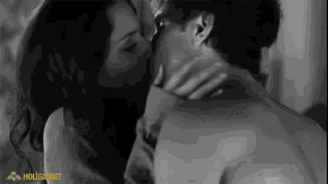 a black and white photo of a man and woman kissing with the words holiganbet on the bottom right