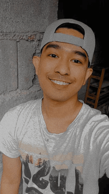 a man wearing a hat and a t-shirt that says ' ucsd ' on it smiles for the camera