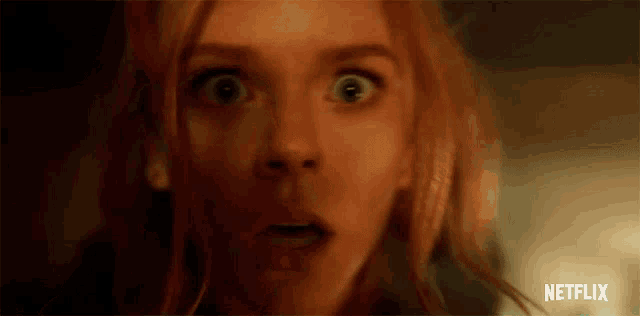 a close up of a woman 's face with a surprised look on her face