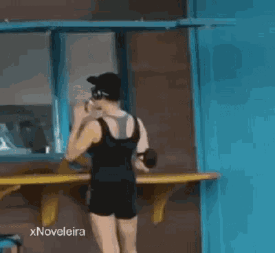 a woman in shorts is standing in front of a window .