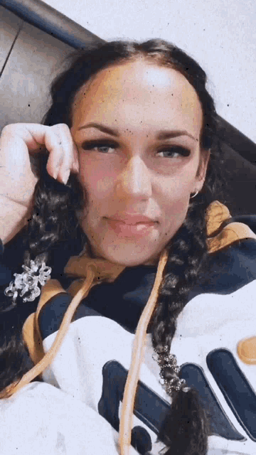 a woman with braids wearing a fila sweatshirt