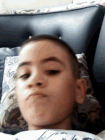 a close up of a child 's face laying on a couch