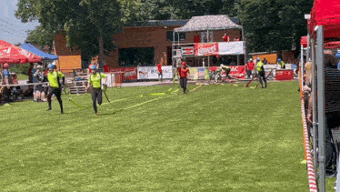 a group of people are running in a field with a banner that says ' litouch ' on it