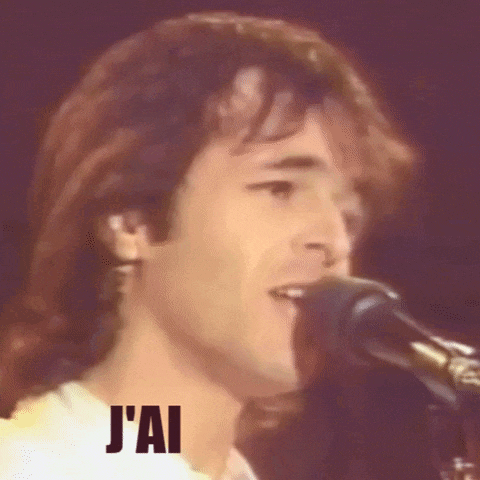 a close up of a man singing into a microphone with the words j'ai written on the bottom